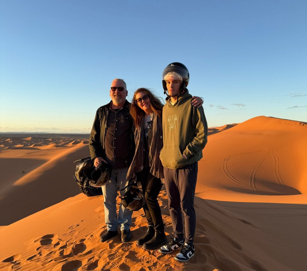 Trois pilotes casqués prêts pour une excursion en quad dans les dunes de Merzouga