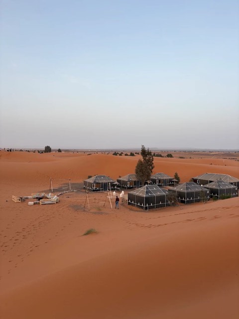 Desert camp tents among the dunes of Erg Chebbi at dusk
