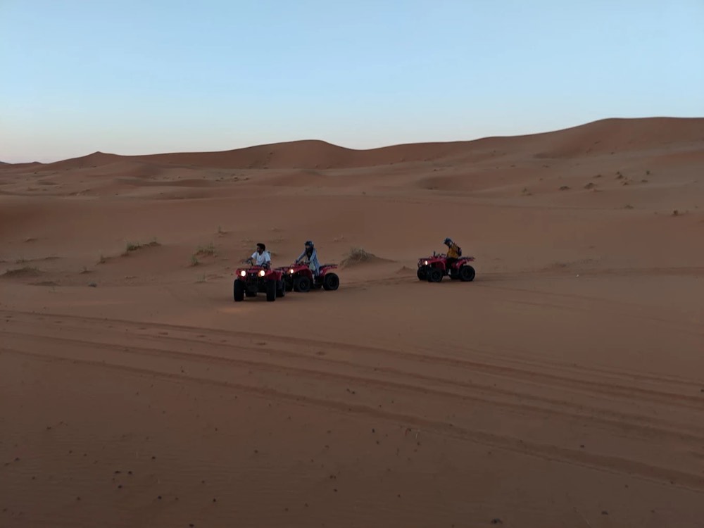 Small group of quads crossing the wide dune valleys of Erg Chebbi