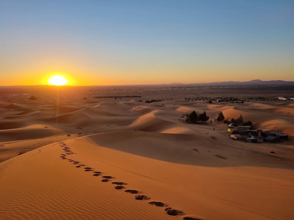 Alba sulle dune dell’Erg Chebbi con impronte nella sabbia