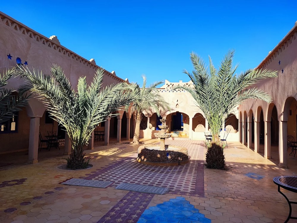 Innenhof mit Palmen in einem Hotel in Merzouga, wo Gäste abgeholt werden