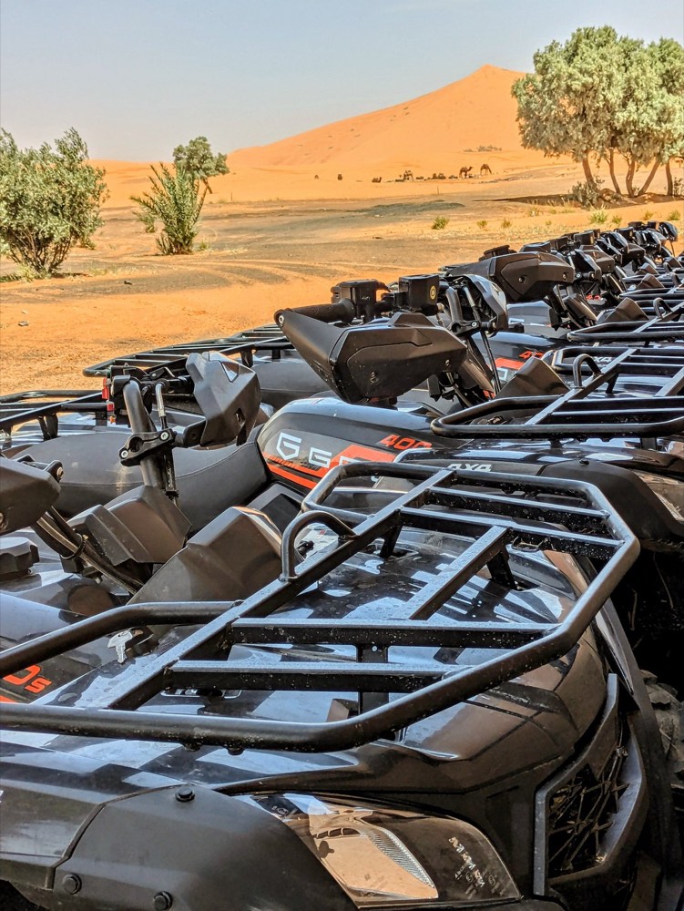 Rangée de quads prêts à la location en bordure des dunes de Merzouga