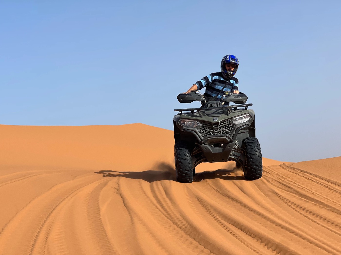 Fahrer auf einem Quad auf einem glatten Dünenkamm im Erg Chebbi, Merzouga