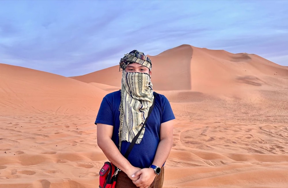 Traveller wearing a desert scarf (chèche) over the face in the Merzouga dunes